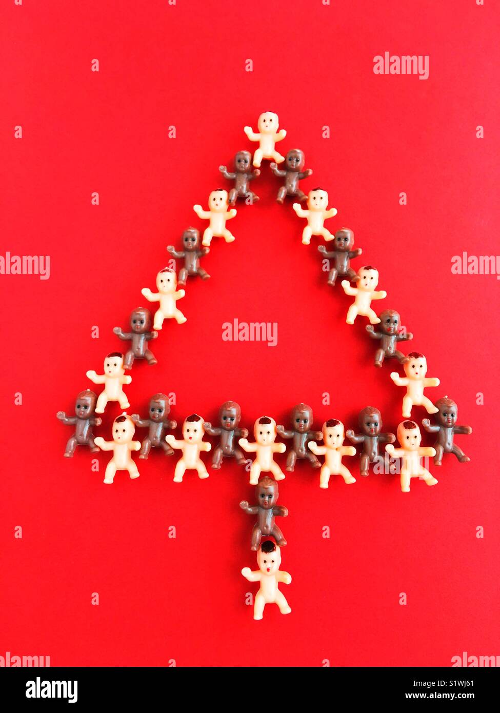 En plastique minuscules baby dolls la forme d'un arbre de Noël. Banque D'Images