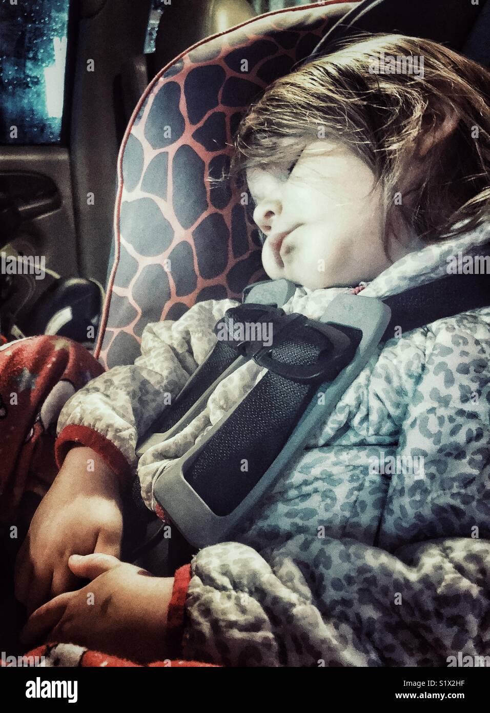Bébé fille dormant dans siège orienté vers l'arrière Banque D'Images