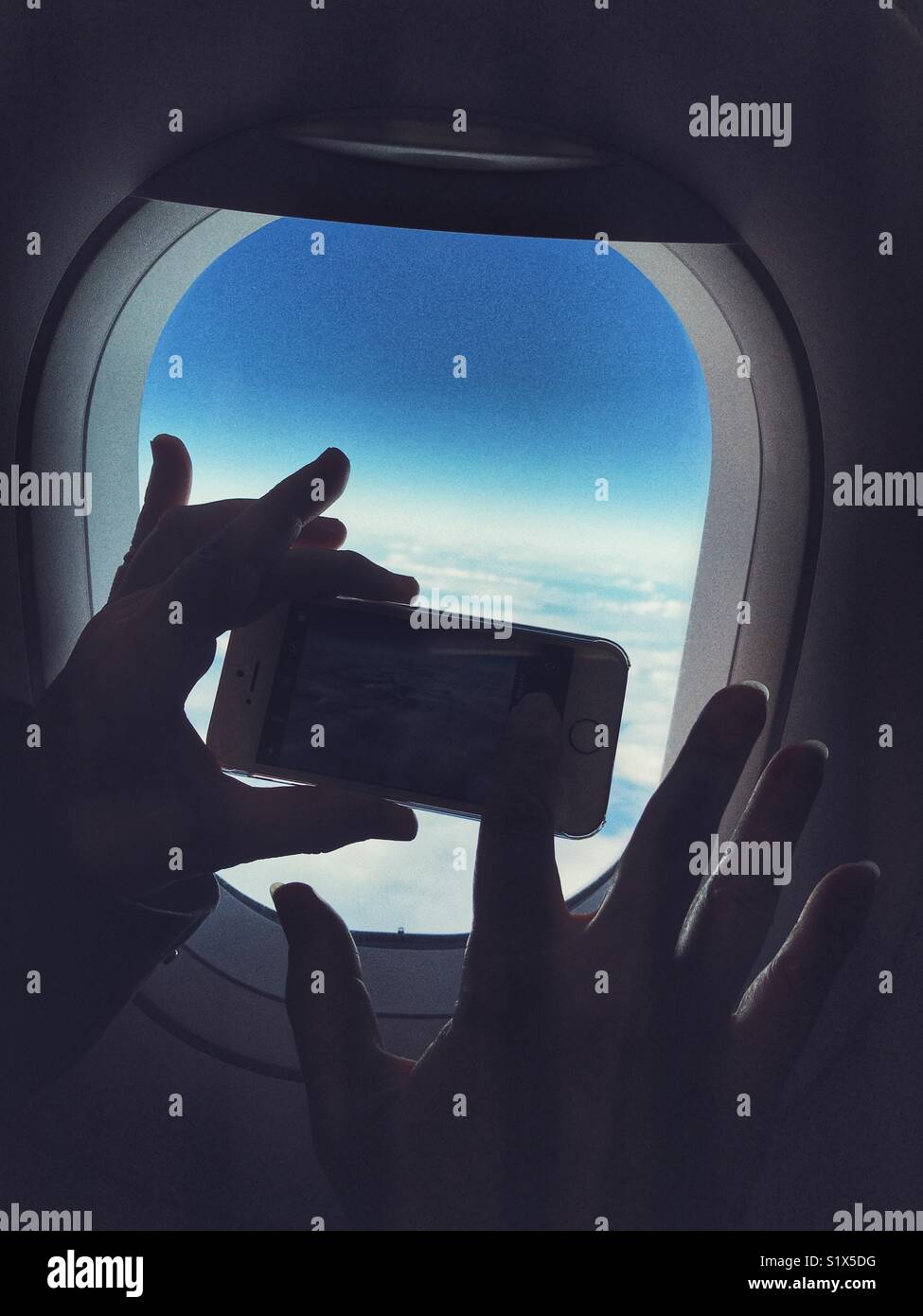 Silhouette de smartphone dans les mains, prise d'une photo hors de la fenêtre d'un avion - Image de stock capturée avec un smartphone