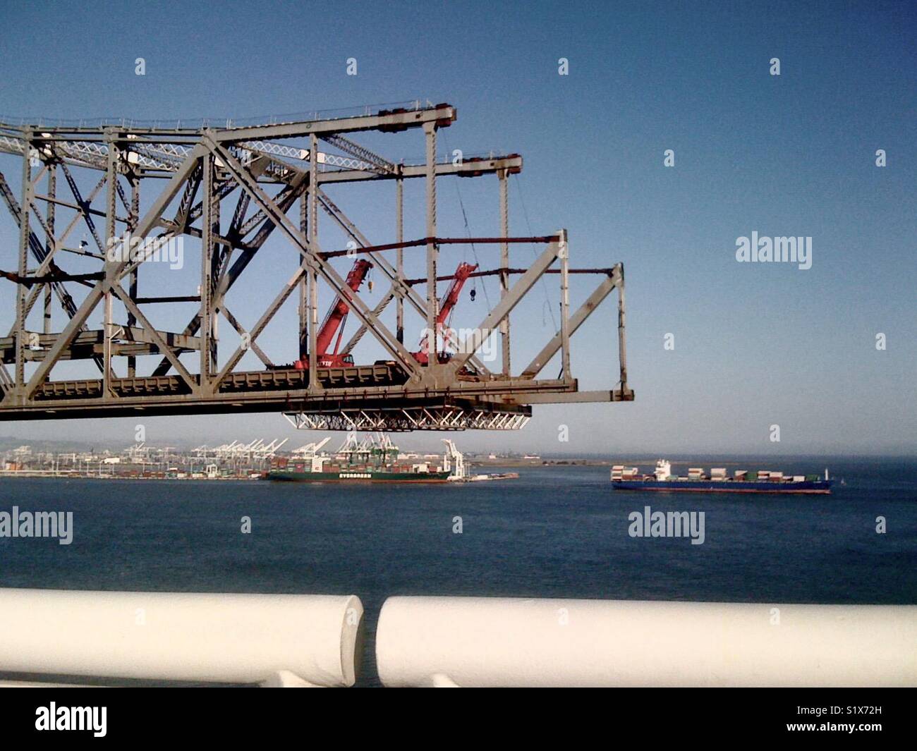 Old Bay Bridge d'être démantelée, la baie de San Francisco. Le port d'Oakland en arrière-plan. Banque D'Images