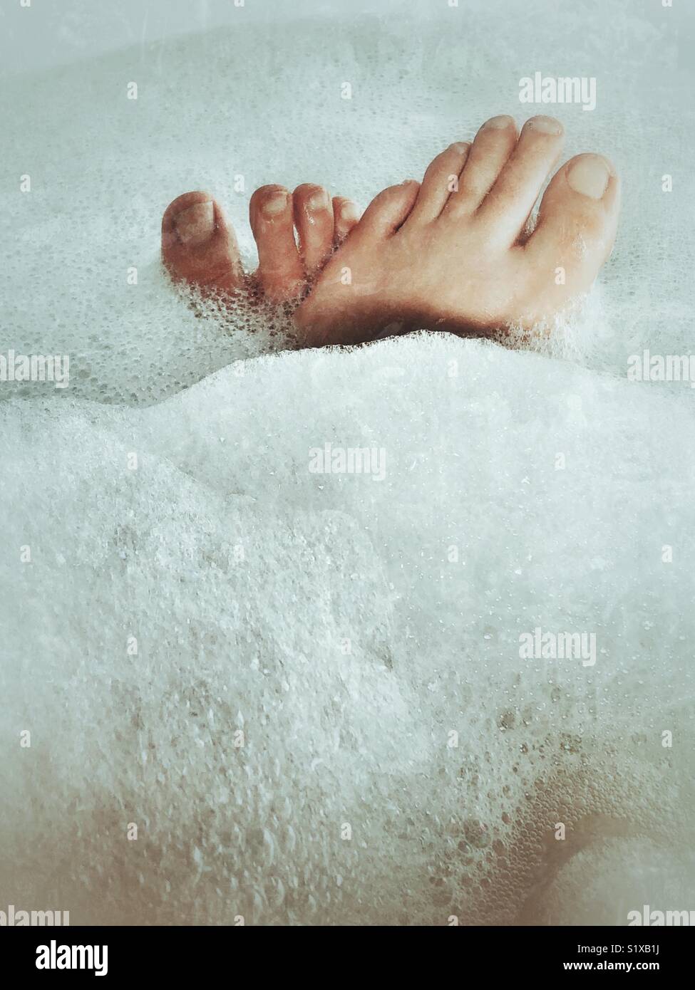 Les pieds des femmes et se termine de bulles dans un bain moussant Banque D'Images