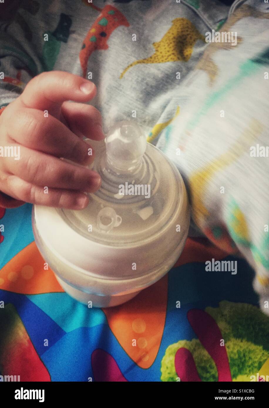 Baby hand holding bouteille de lait Banque D'Images