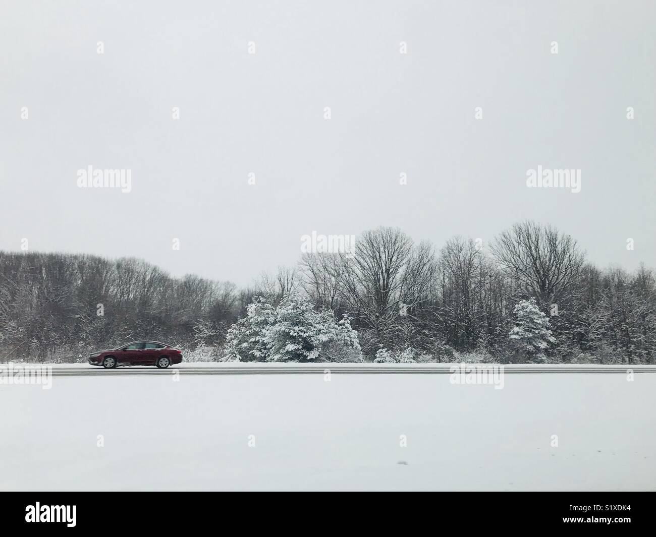 Snow road et une voiture. Météo noir et blanc Banque D'Images