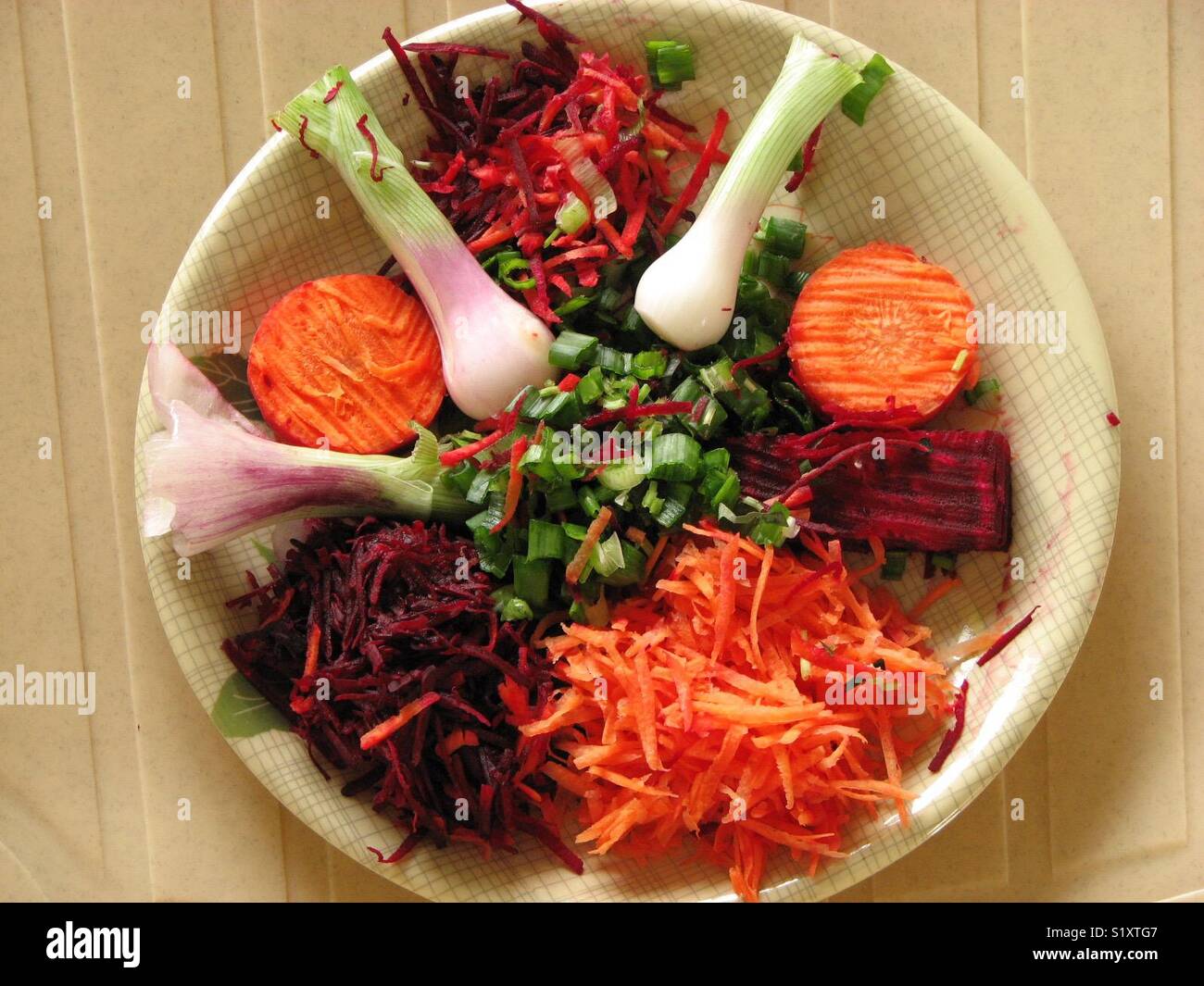 Salade colorée : un beau mélange de carottes râpées, racines de betterave, oignon de printemps et feuilles. Banque D'Images