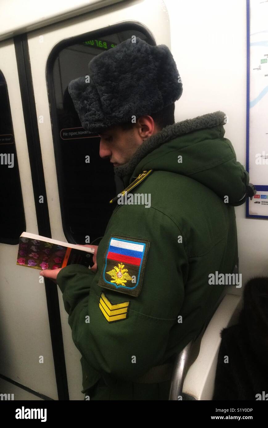 ST. PETERSBURG, RUSSIE - février 27, 2018 : Fédération de militar de lire un livre dans le métro. Banque D'Images