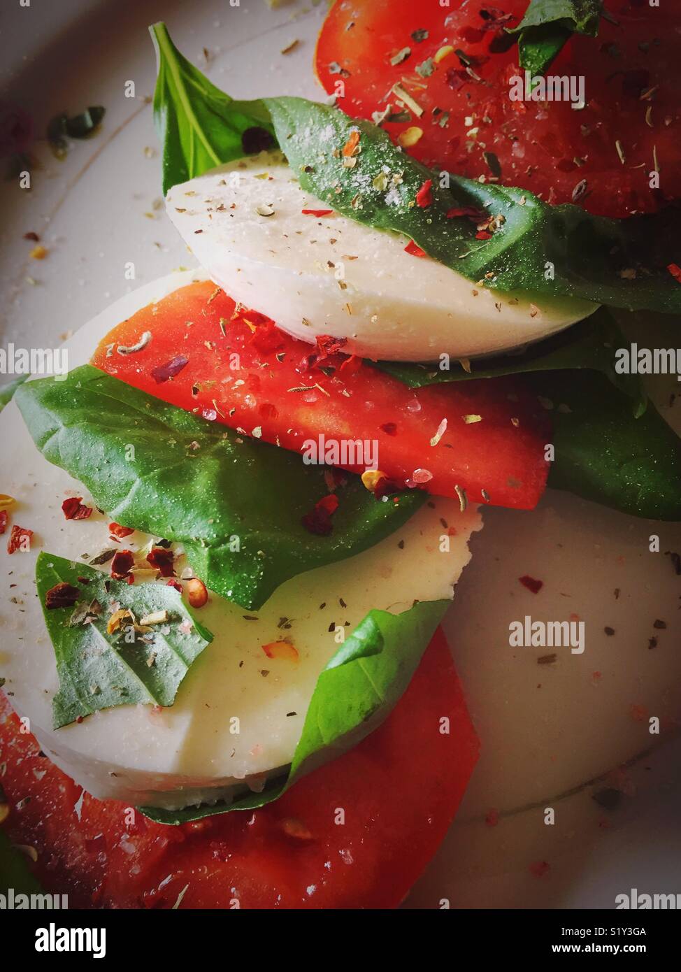 Freshly sliced mozzarella, tomate et basilic salade est habillé avec de l'huile d'olive - Image de stock capturée avec un smartphone
