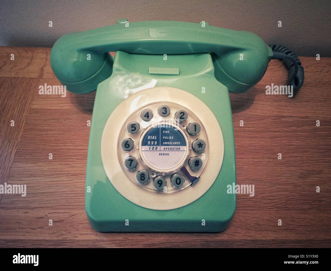 Un style rétro, old fashioned téléphone avec cadran circulaire sur un fond de bois - Image de stock capturée avec un smartphone