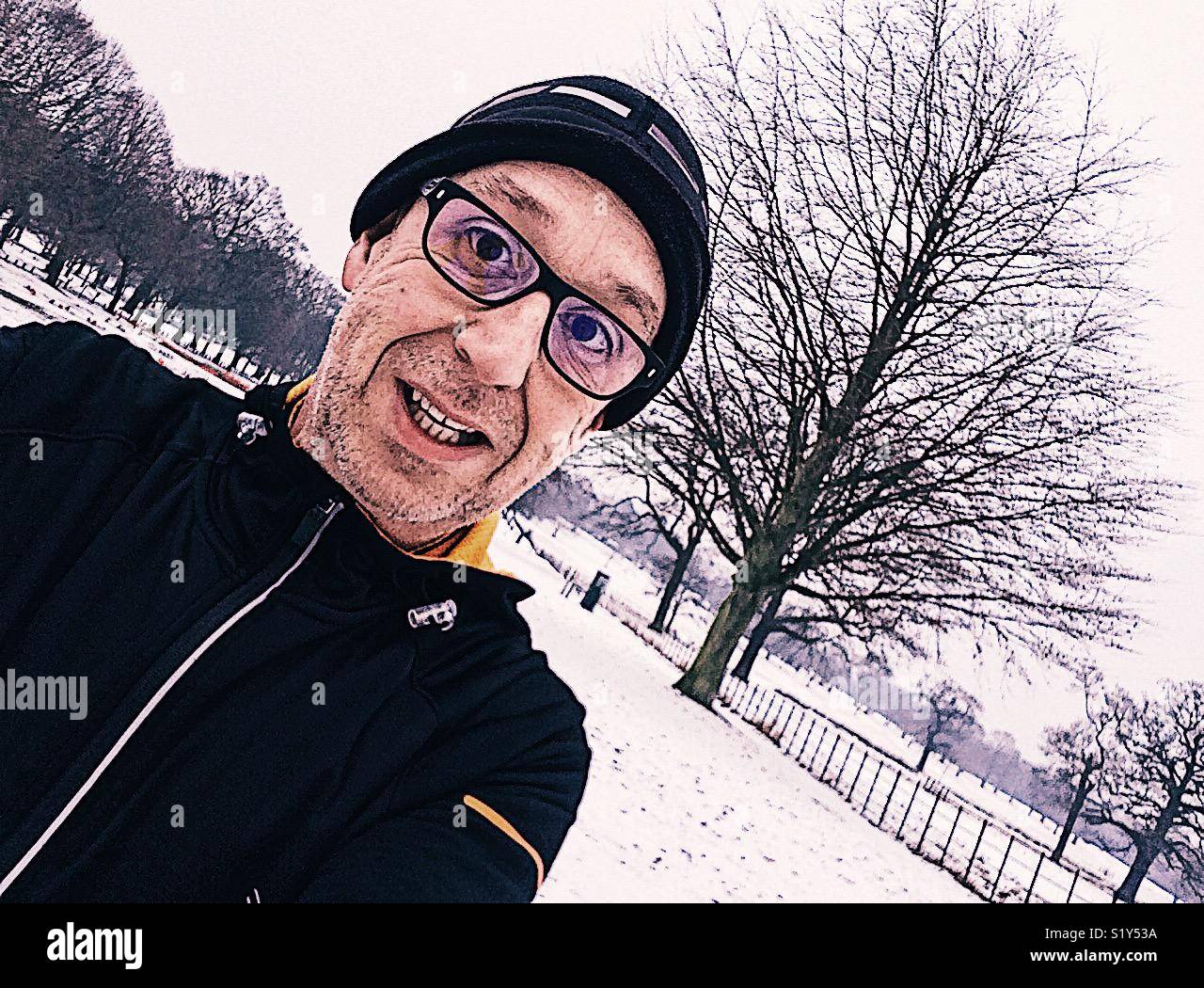 Middle aged man running in snow Banque D'Images