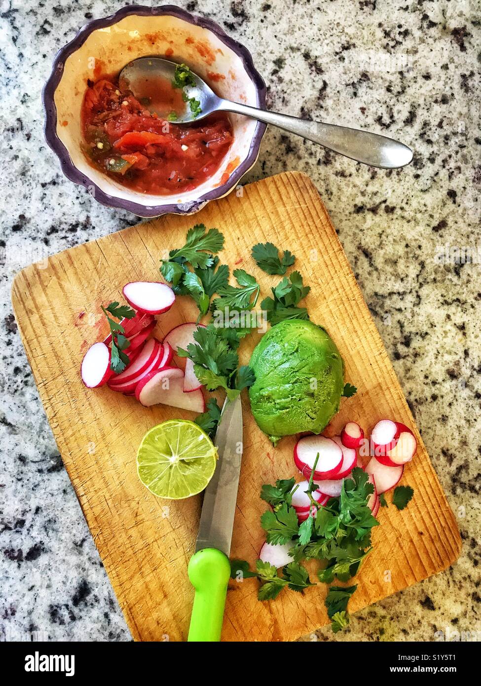Garnitures délicieuses pour nourriture mexicaine avec les radis, la coriandre, l'avocat, et de la chaux sur une planche à découper, et de la salsa dans un petit bol. Banque D'Images
