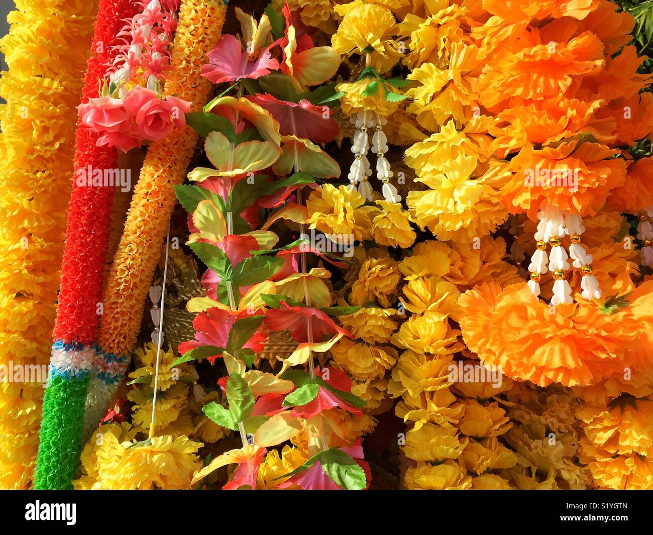 Des guirlandes de fleurs jaune et orange à la sanctuaire bouddhiste Banque D'Images