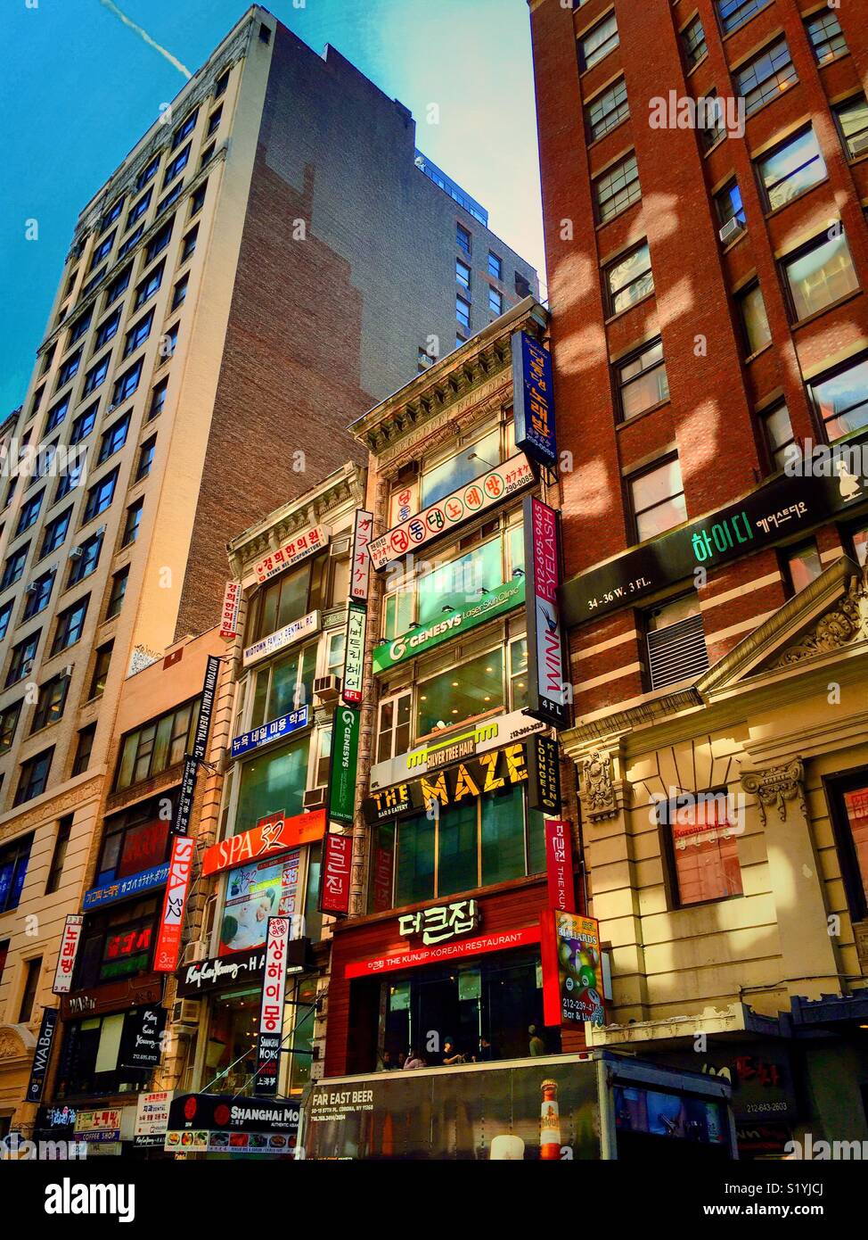 Devantures aux couleurs vives avec signalisation multilingue dans Koreatown, W. 32nd Street, New York City, USA Banque D'Images