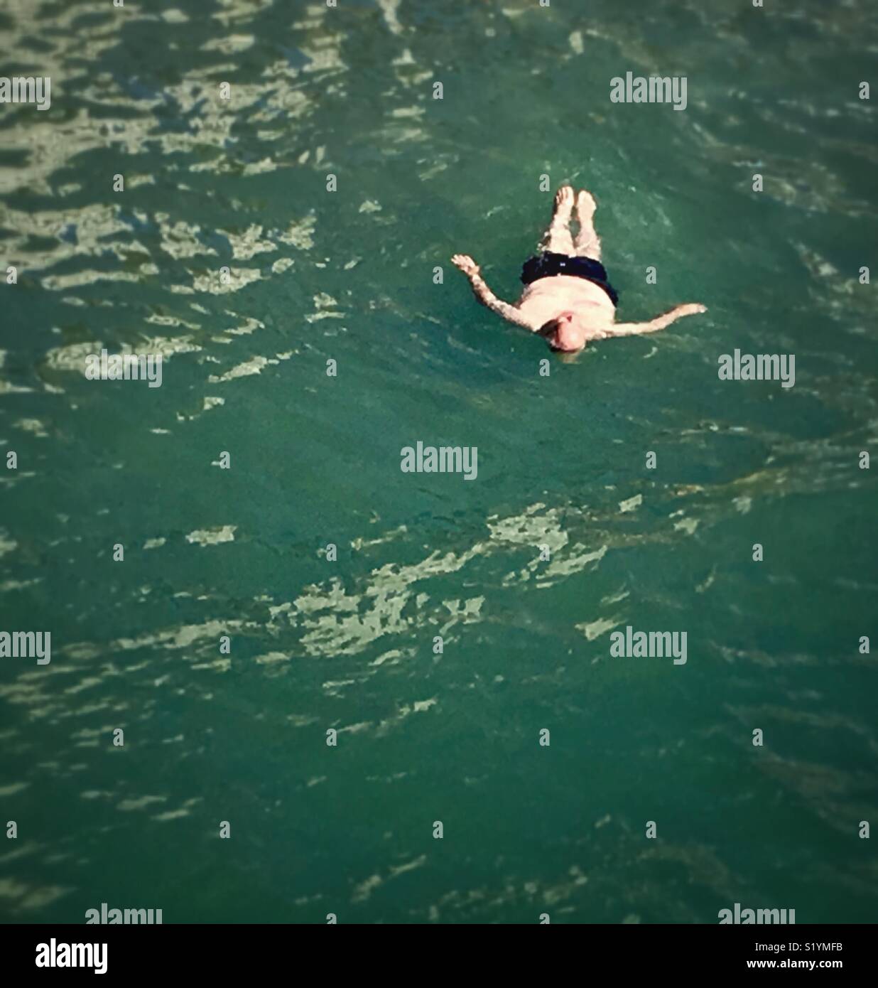 L'homme à la retraite qui flotte sur son dos dans l'eau, Natation en vacances. Banque D'Images