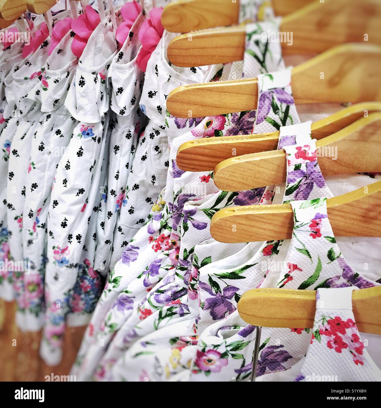Floral Robes bébé mignon sur cintres en bois à vendre dans la boutique Banque D'Images