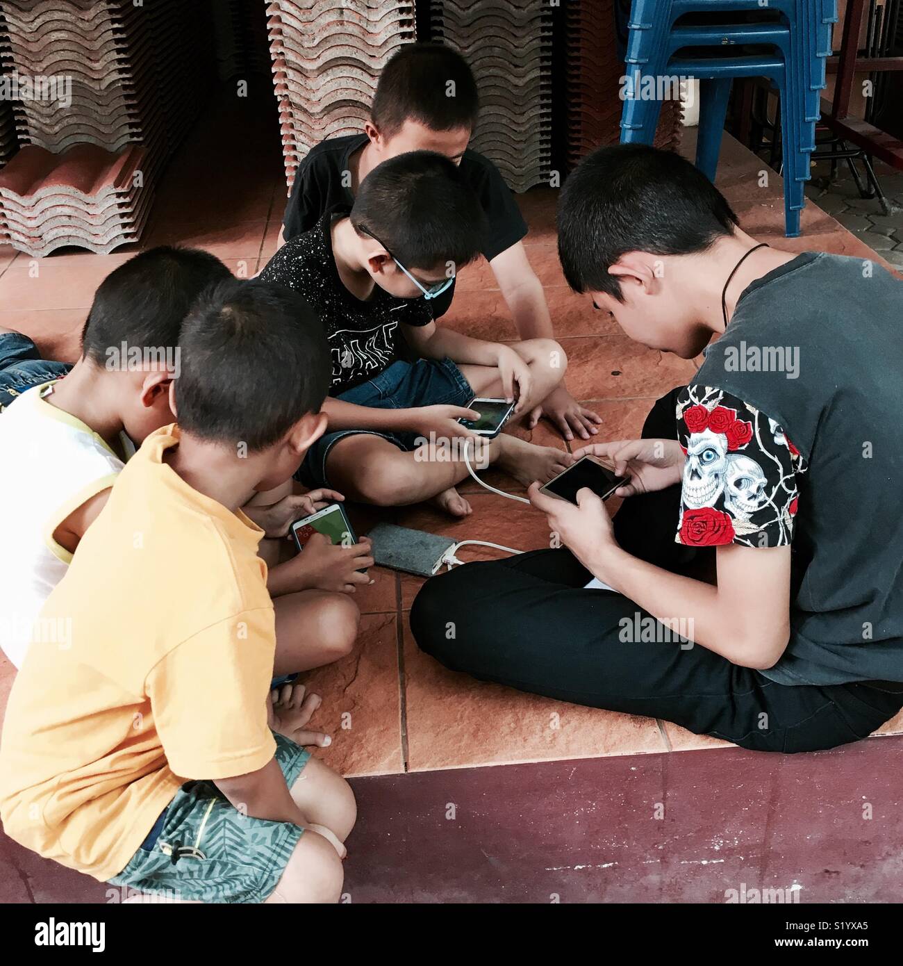 Les enfants thaïlandais de jouer sur leur téléphone mobile Banque D'Images