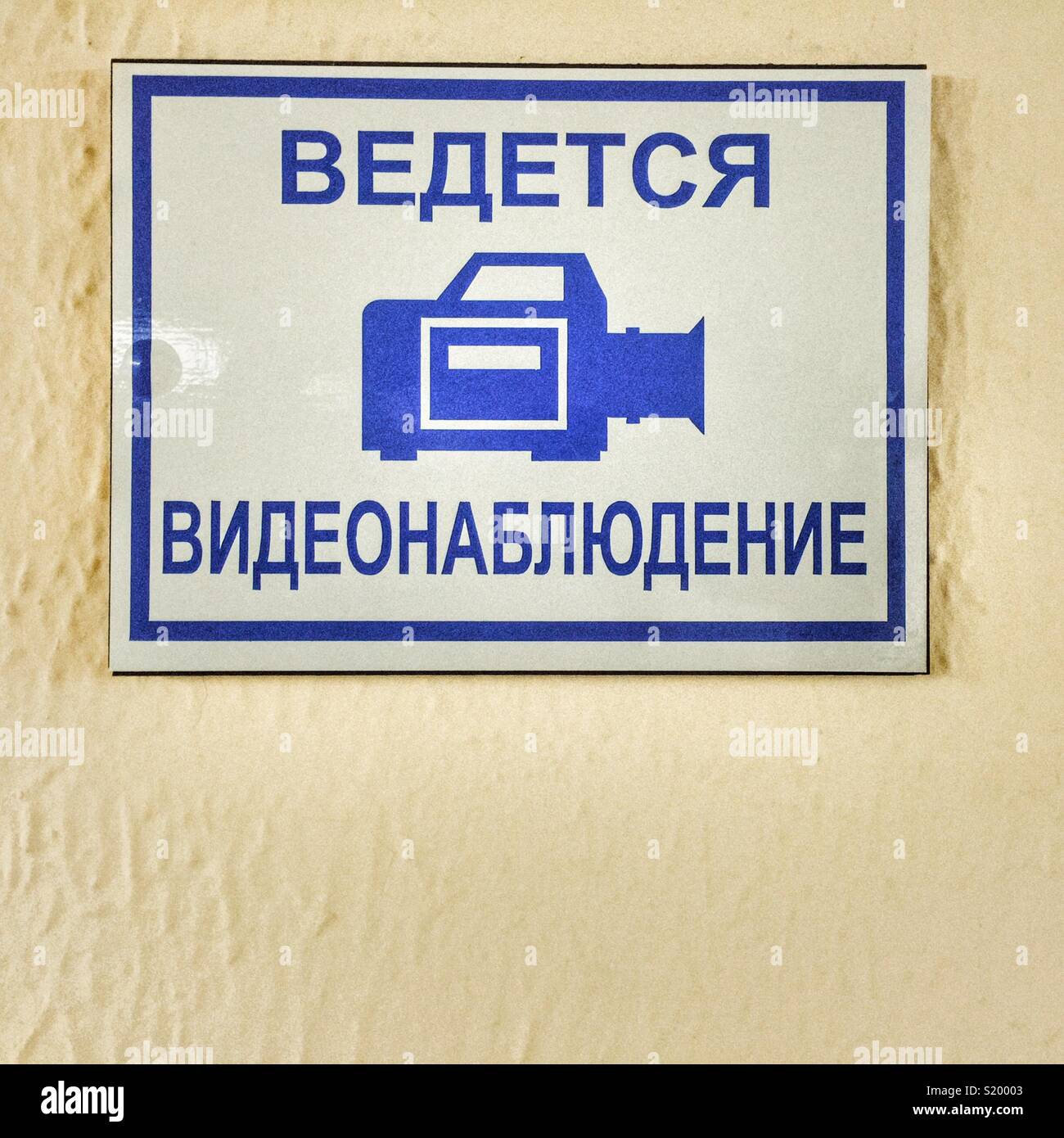 Signe de surveillance vidéo en langue russe sur le mur dans une clinique médicale Banque D'Images
