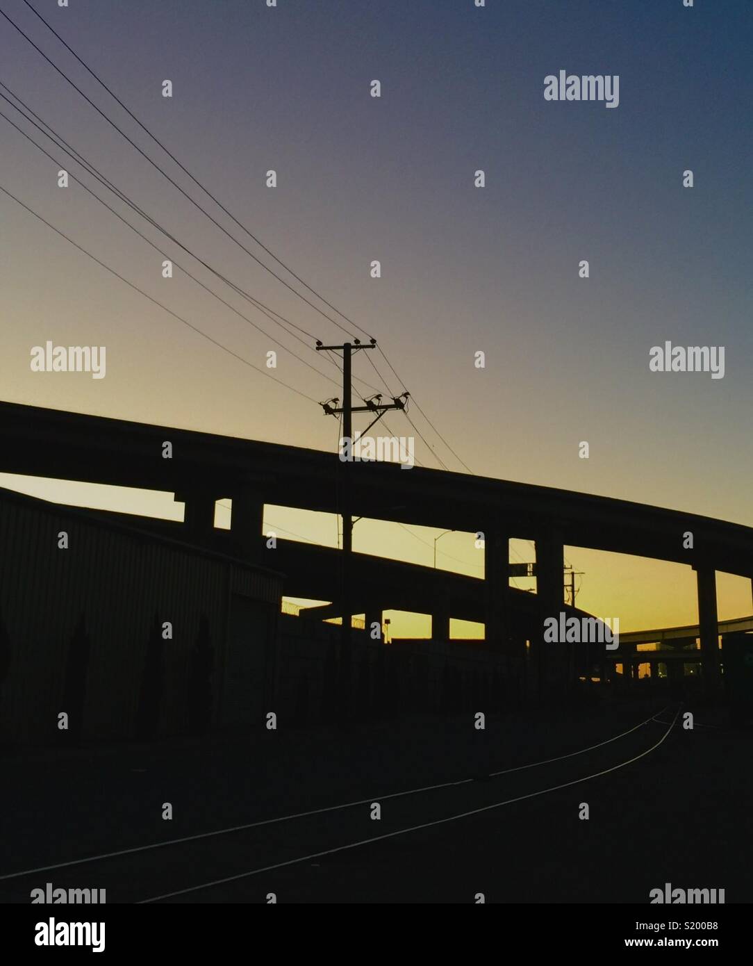 Les viaducs de l'autoroute et les voies du téléphérique au coucher du soleil. Banque D'Images