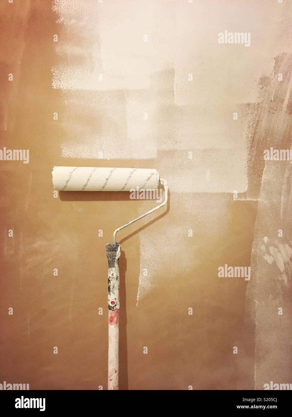 Rouleau de peinture s'appuyant sur un mur bricolage ménage - Image de stock capturée avec un smartphone