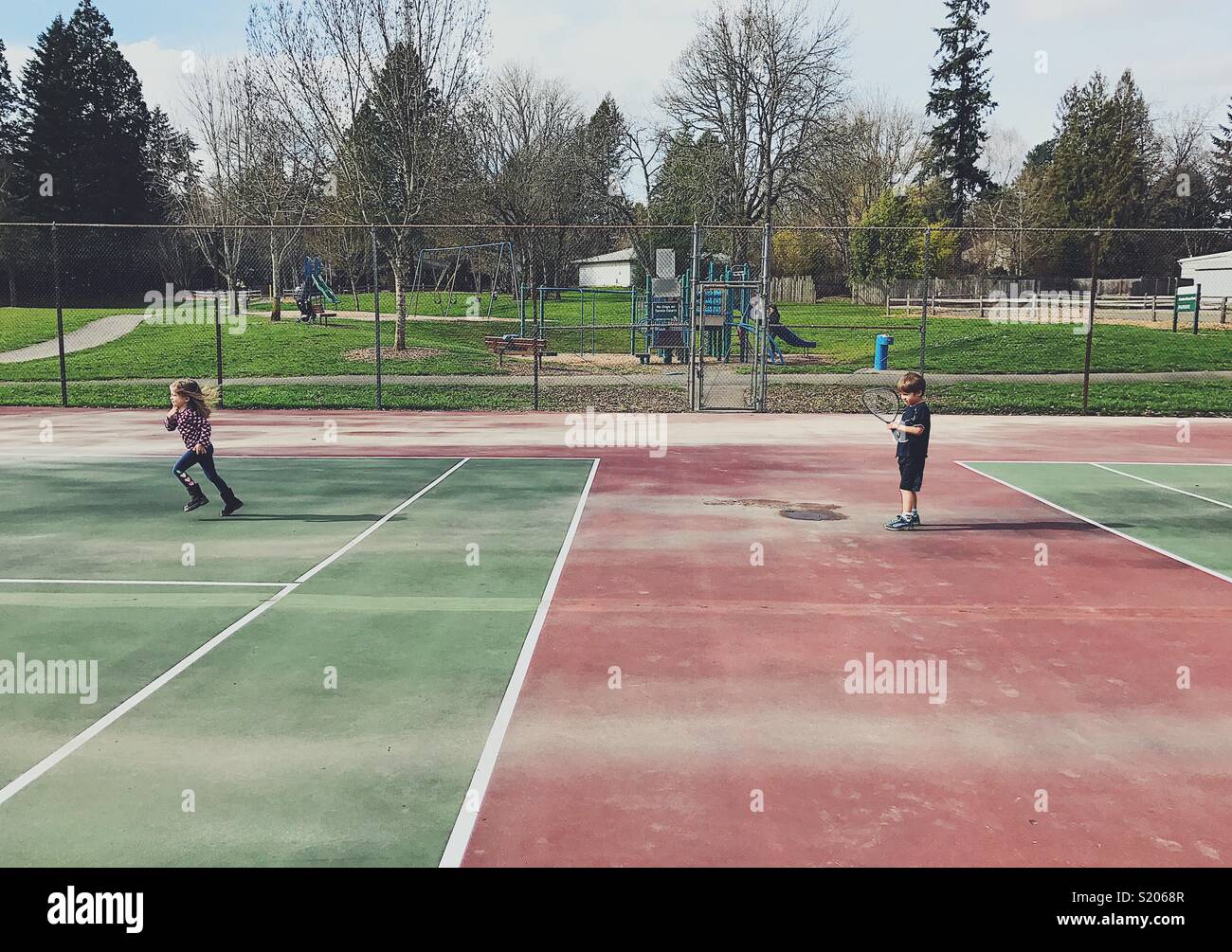 Peu d'enfants qui jouent sur un court de tennis Banque D'Images