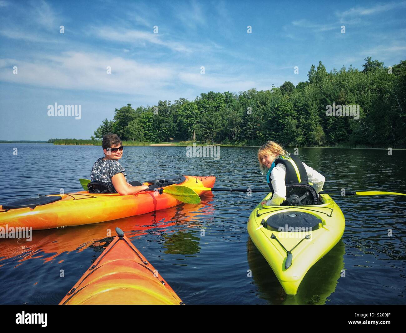 Kayak sur un lac. Mère et fille se retourna pour photo shot. Banque D'Images