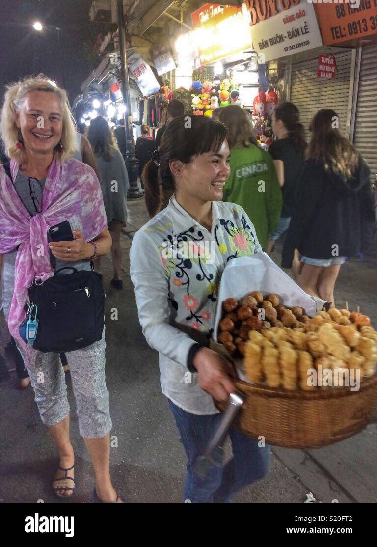 Deux femmes souriant à un marché de nuit à Ho Chi Minh City, Vietnam. - Image de stock capturée avec un smartphone