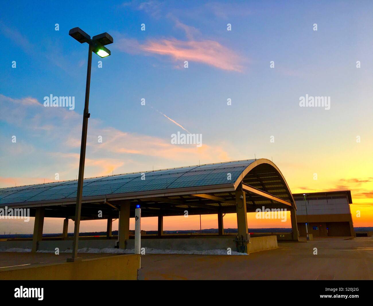 Coucher du soleil au-dessus de garage avec auvent couvert Banque D'Images