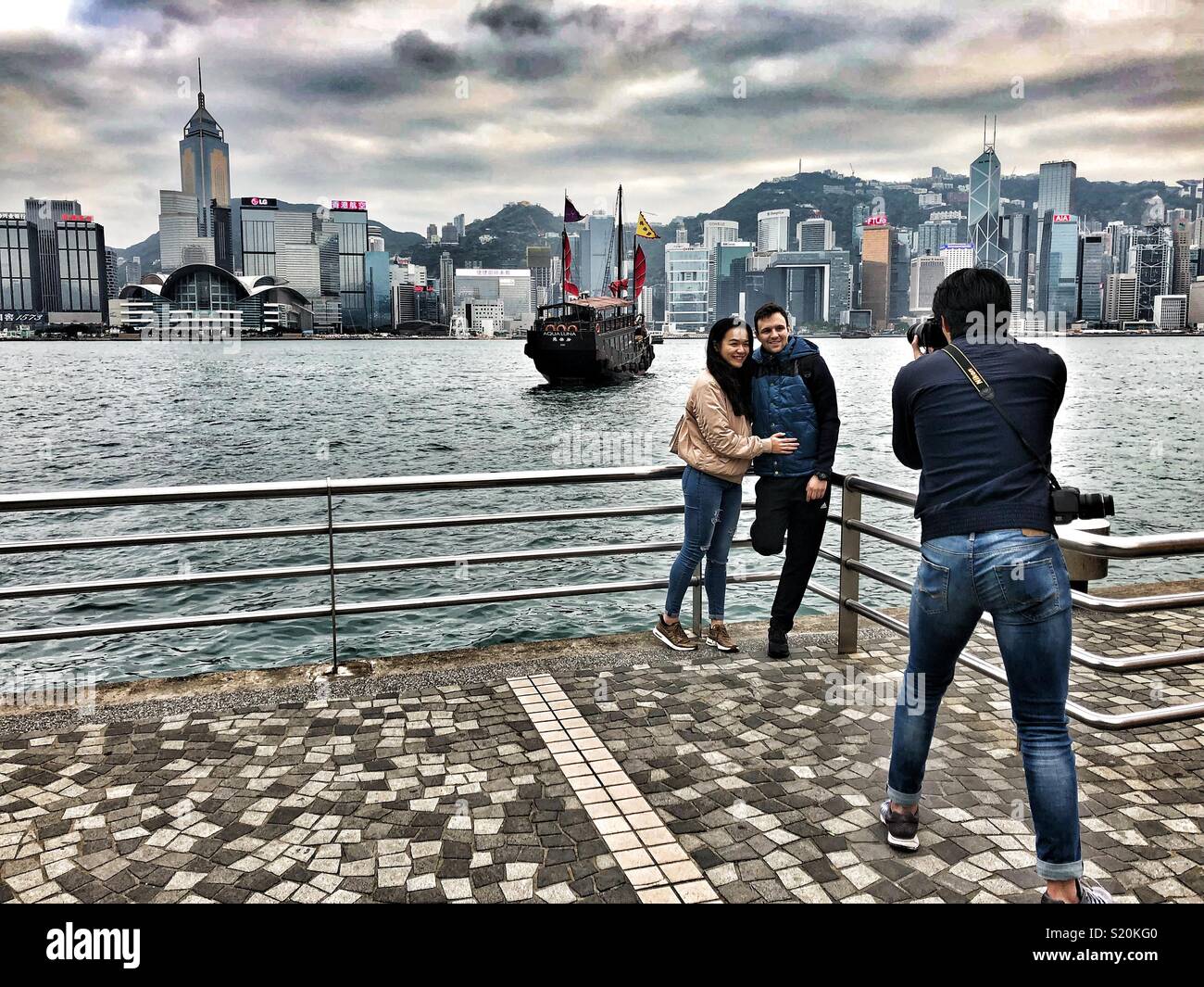 Un photographe prend des photos d'un couple sur le front de mer de Hong Kong. Banque D'Images