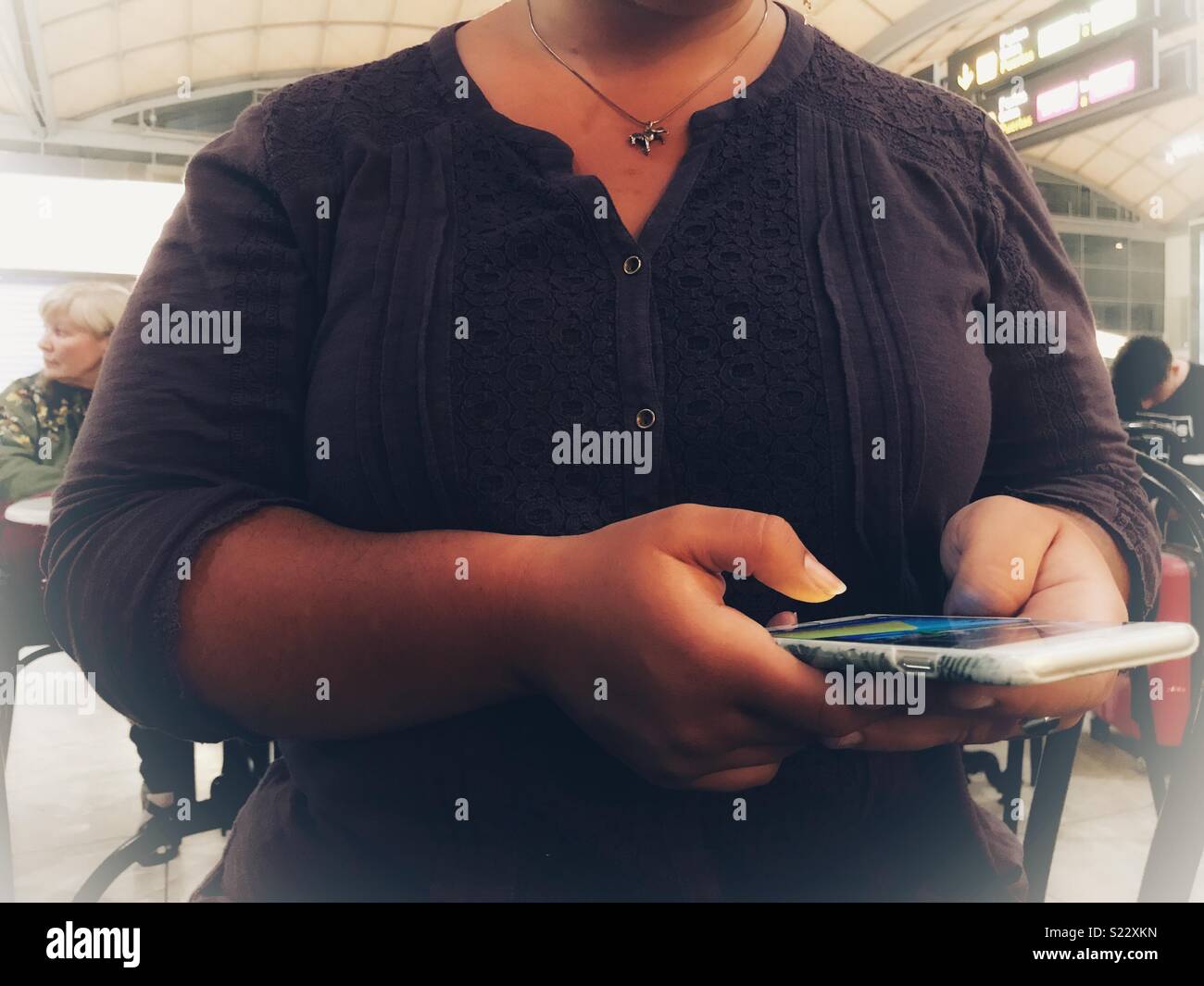 Femme à l'aide d'un smartphone à l'aéroport - Image de stock capturée avec un smartphone