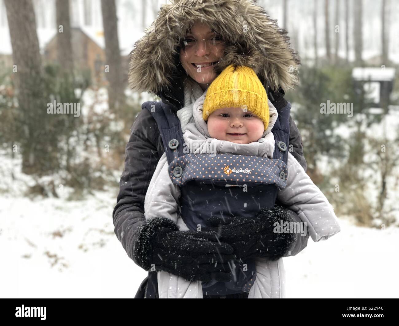 Les femmes holding baby dans la neige Banque D'Images