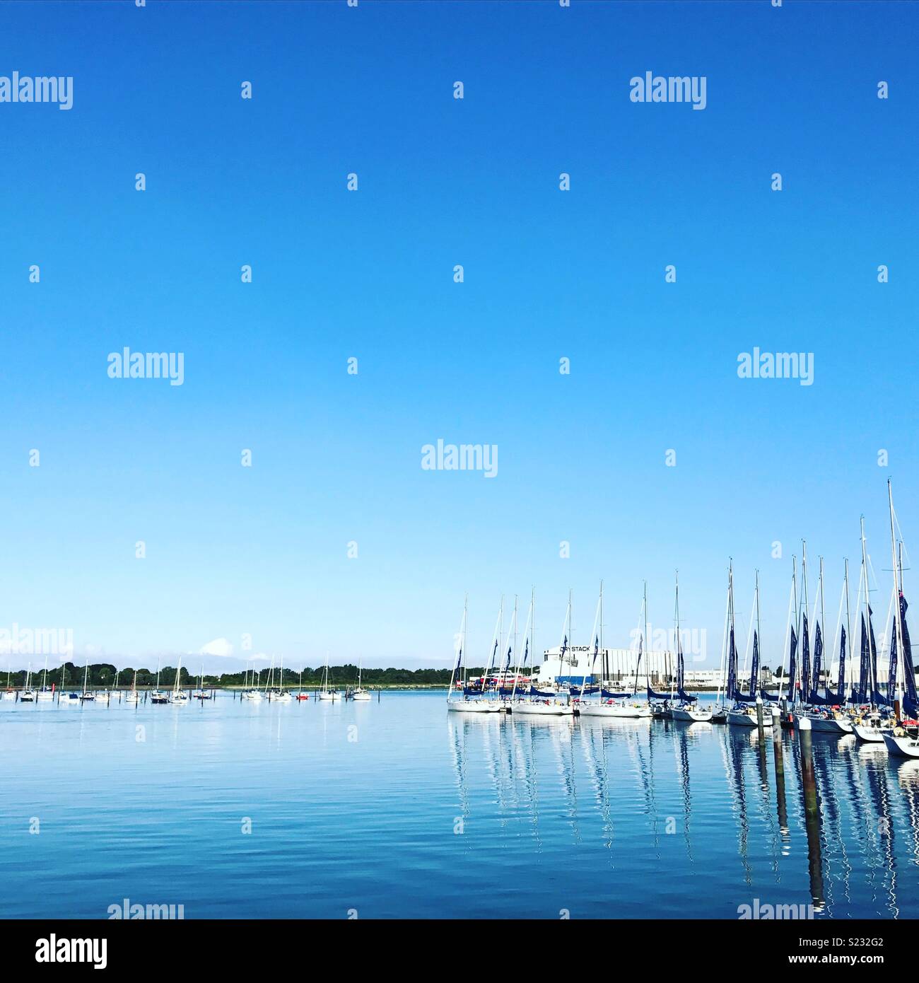 Rangée de bateaux sur le ponton dans le Solent sous un ciel bleu Banque D'Images