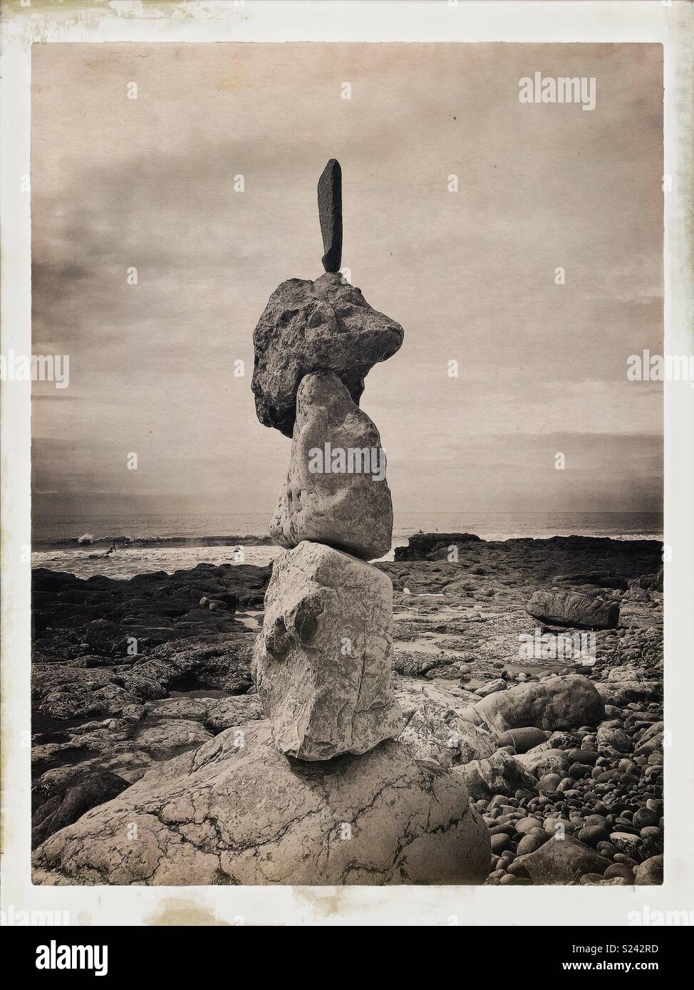 La pierre naturelle/rock sculpture d'équilibrage sur la plage avec des vagues. Banque D'Images