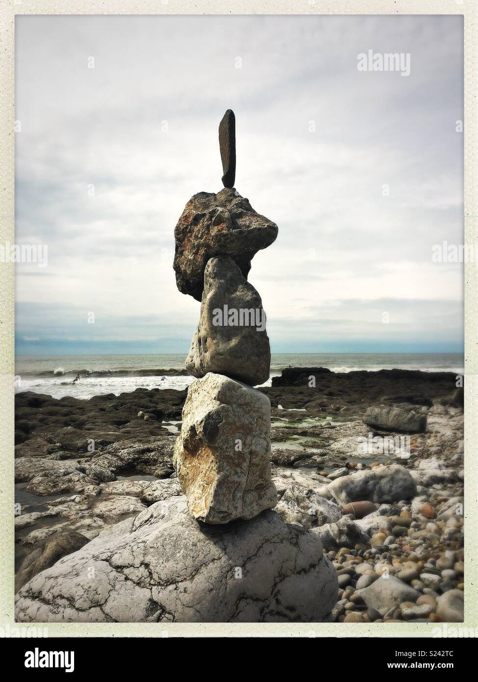 La pierre naturelle/rock sculpture d'équilibrage sur la plage avec des vagues. Banque D'Images