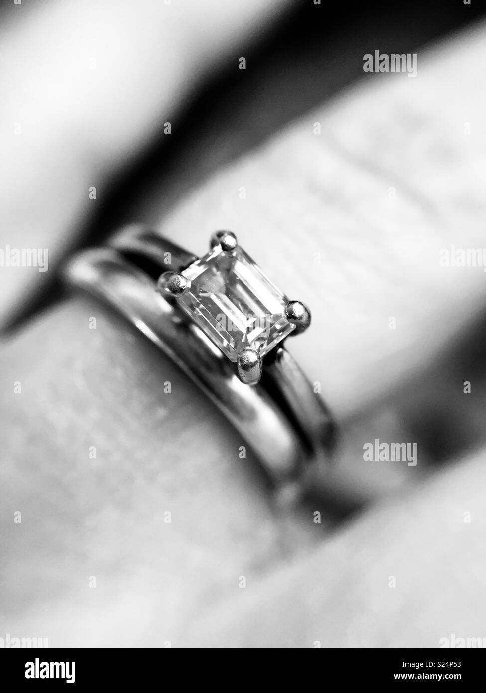 Bague de fiançailles en diamants et bande de mariage sur mesdames doigt en noir et blanc Banque D'Images