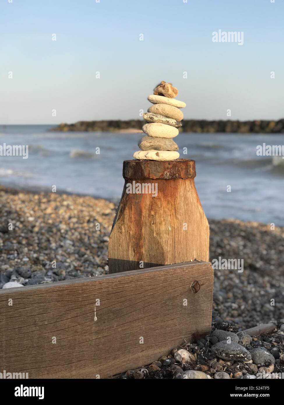 Tas de pierres sur un épi avec la mer et les rochers en arrière-plan, à Elmer, Bognor Regis. Banque D'Images