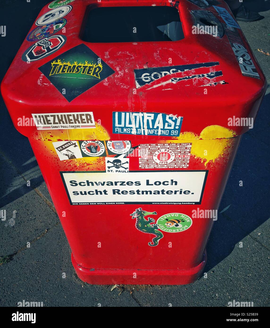 Poubelle autocollant rouge - "trou noir cherche déchet". - Image de stock capturée avec un smartphone