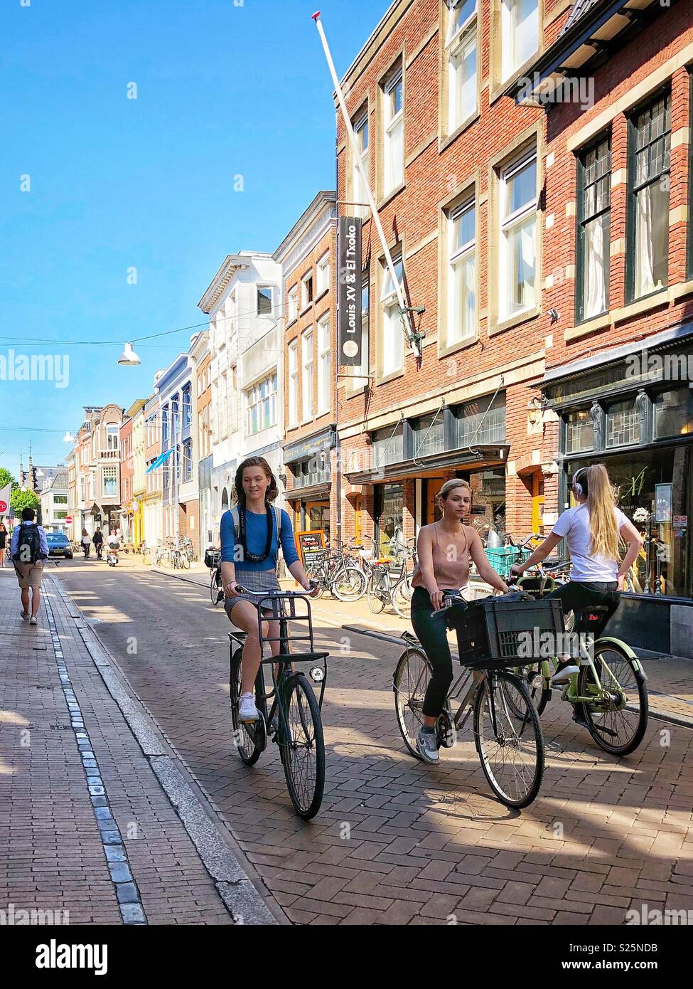 Les cyclistes de sexe féminin sur une rue. Groningen, Pays-Bas Banque D'Images