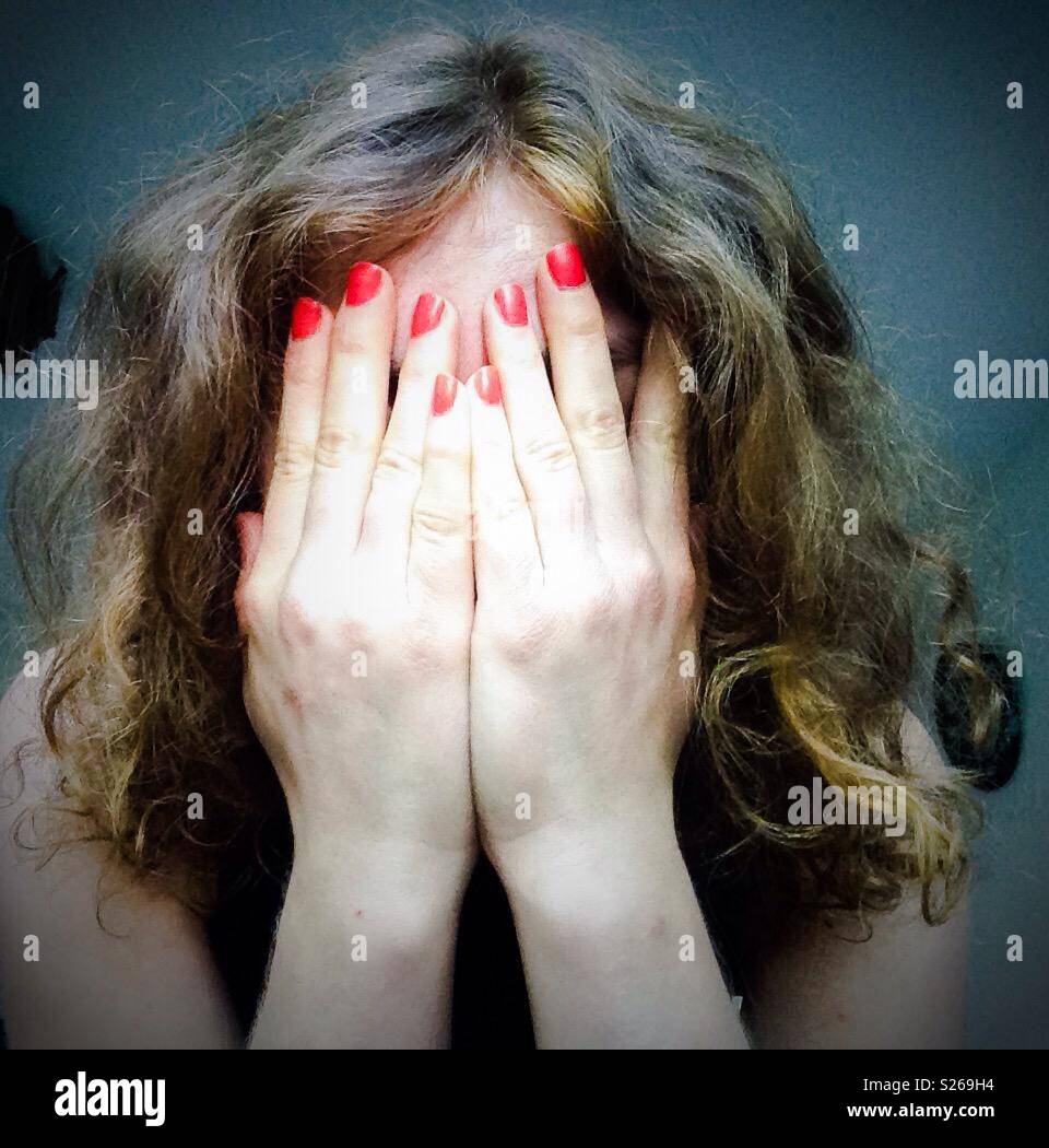 Femme avec des paumes sur son visage Banque D'Images