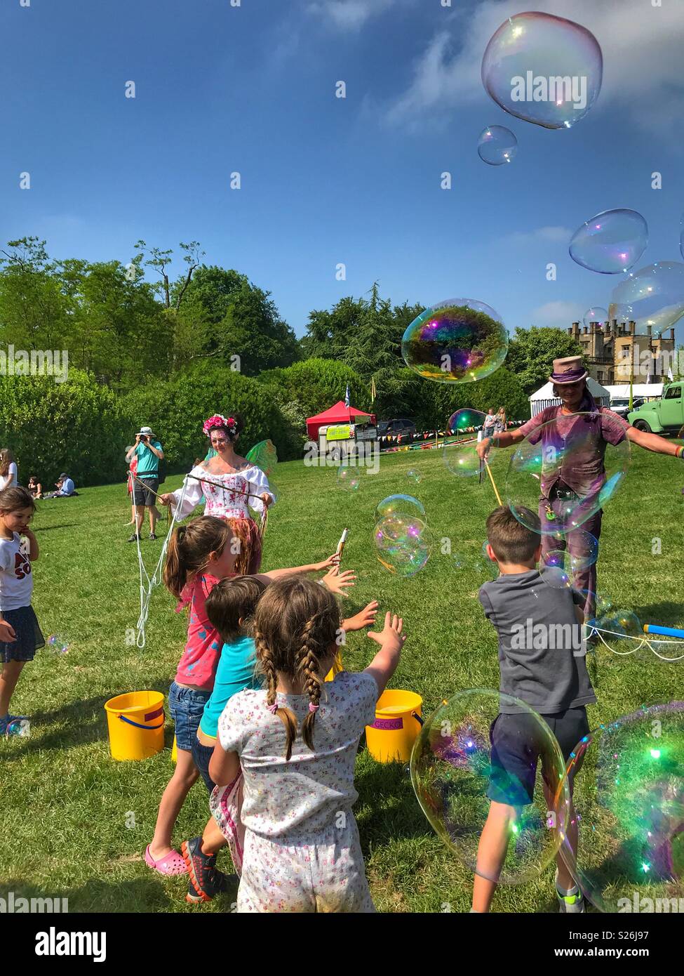 Bubbleman créer des bulles de savon, et les enfants d'essayer de les faire éclater, le château de Sherborne Country Fair, Sherborne, Dorset, Angleterre Banque D'Images