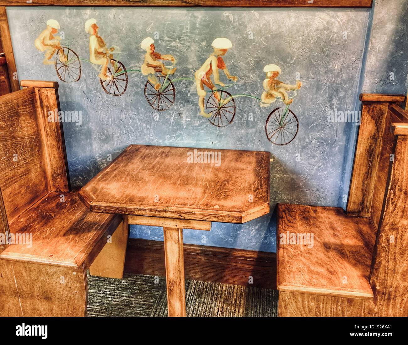 Taille de l'enfant table et chaises à côté de fresque de personnes sur monocycles Banque D'Images