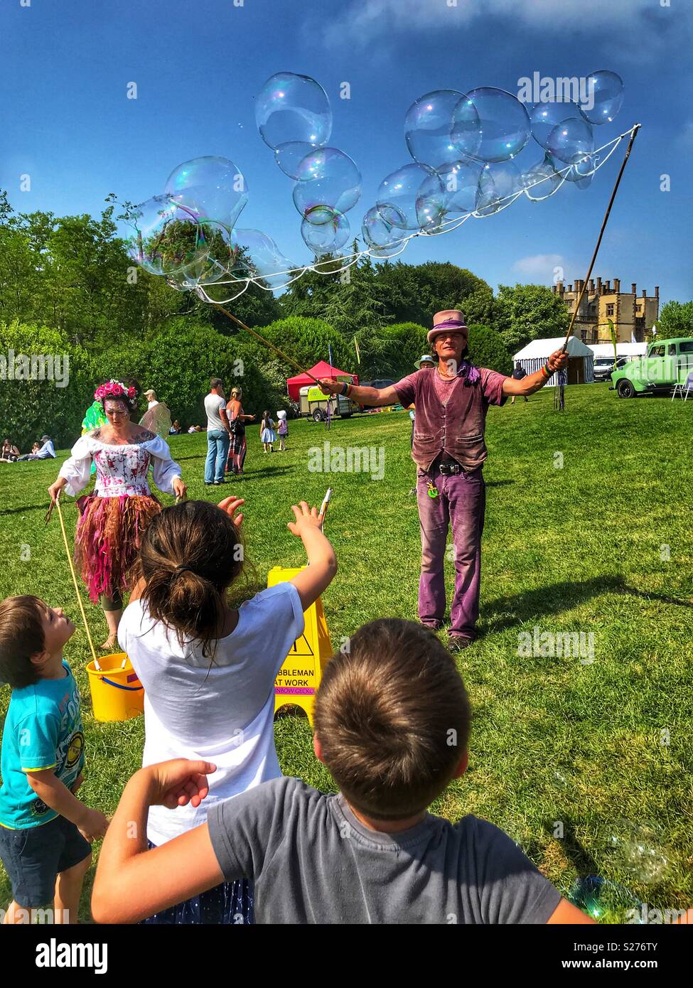 La création de l'homme des bulles de savon géantes, Amusant les enfants à Sherborne Castle Country Fair, Sherborne, Dorset, Angleterre Banque D'Images