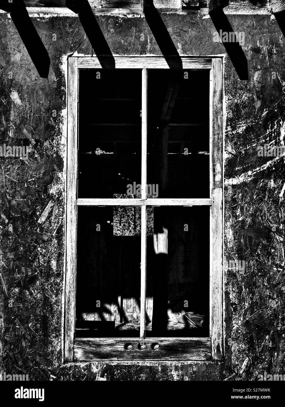 En regardant par la fenêtre d'un vieux bâtiment abandonné creepy (version monochrome). - Image de stock capturée avec un smartphone