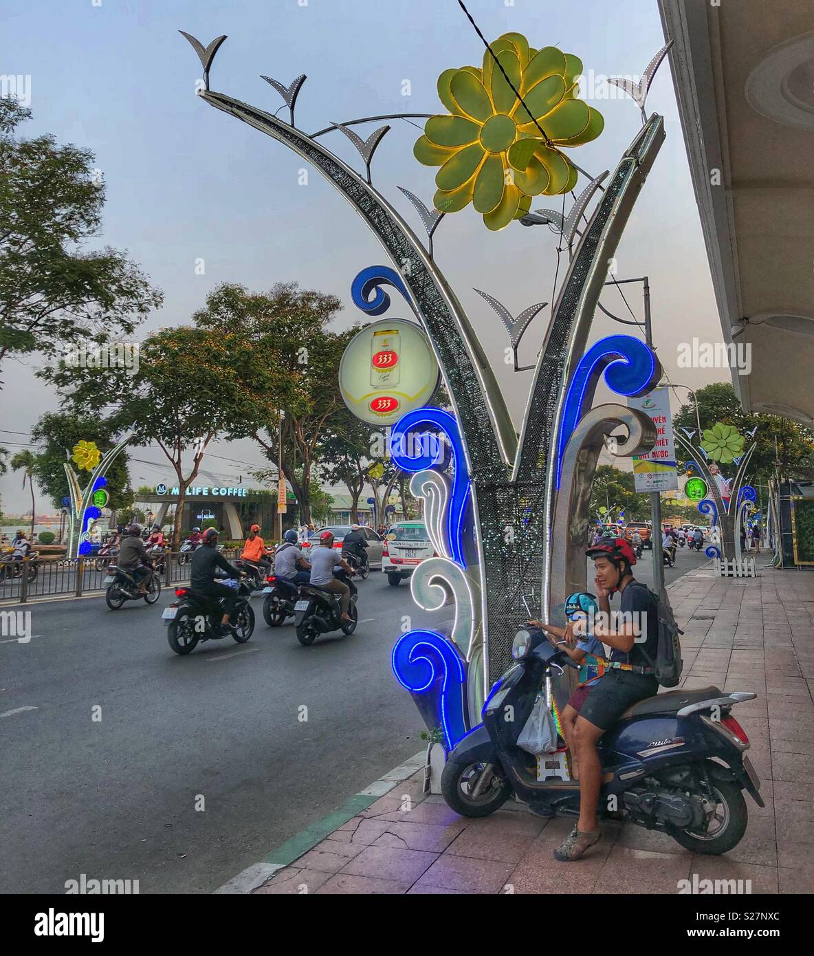 Père et fils sur un cyclomoteur à Ho Chi Minh City, Vietnam. - Image de stock capturée avec un smartphone