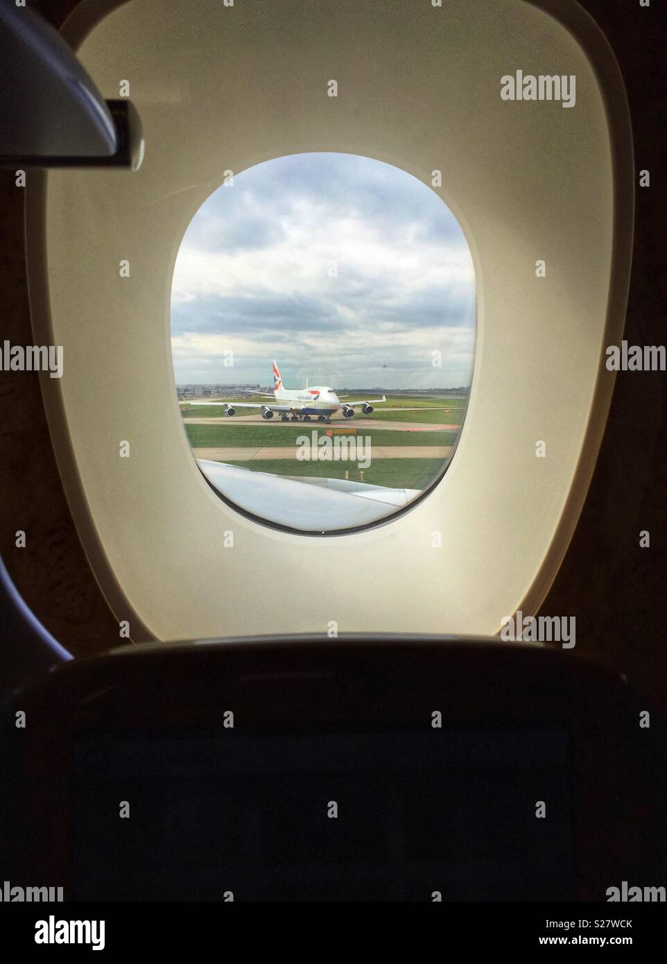 Un Boeing 747 de British Airways vu circuler à travers la fenêtre de l'Unis siège en classe affaires. L'aéroport de Heathrow, Londres, Royaume-Uni - Image de stock capturée avec un smartphone