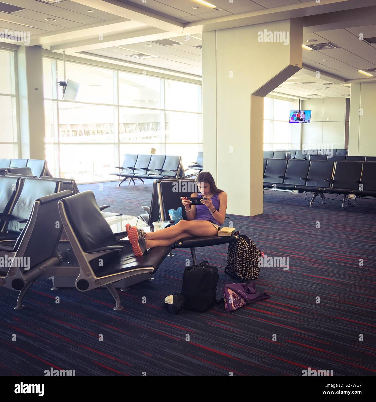 Girl passe temps en attendant à l'aéroport. Banque D'Images