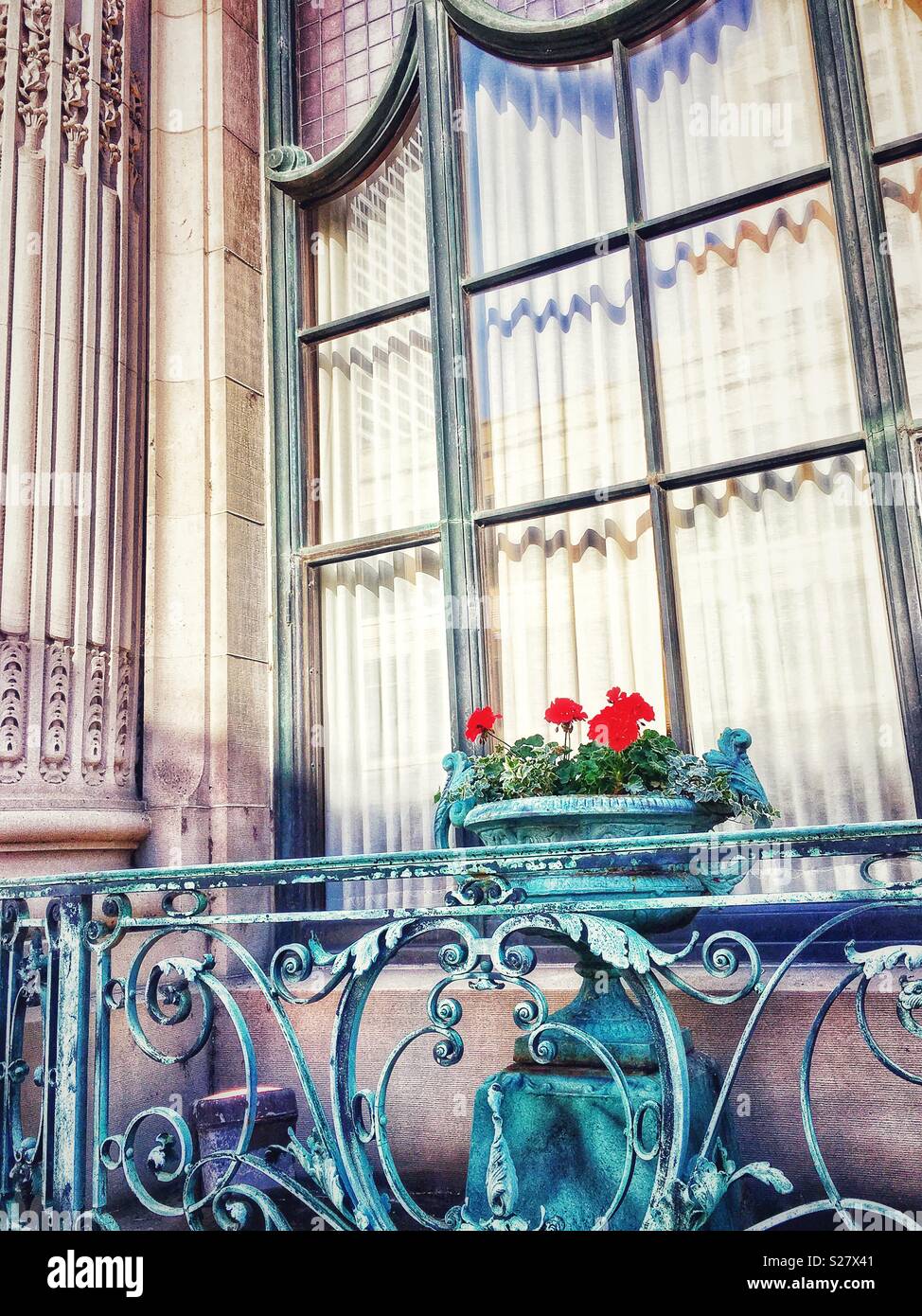 Pot de fleurs en cuivre rouge avec fleurs sur le balcon de cuivre par colonne Banque D'Images