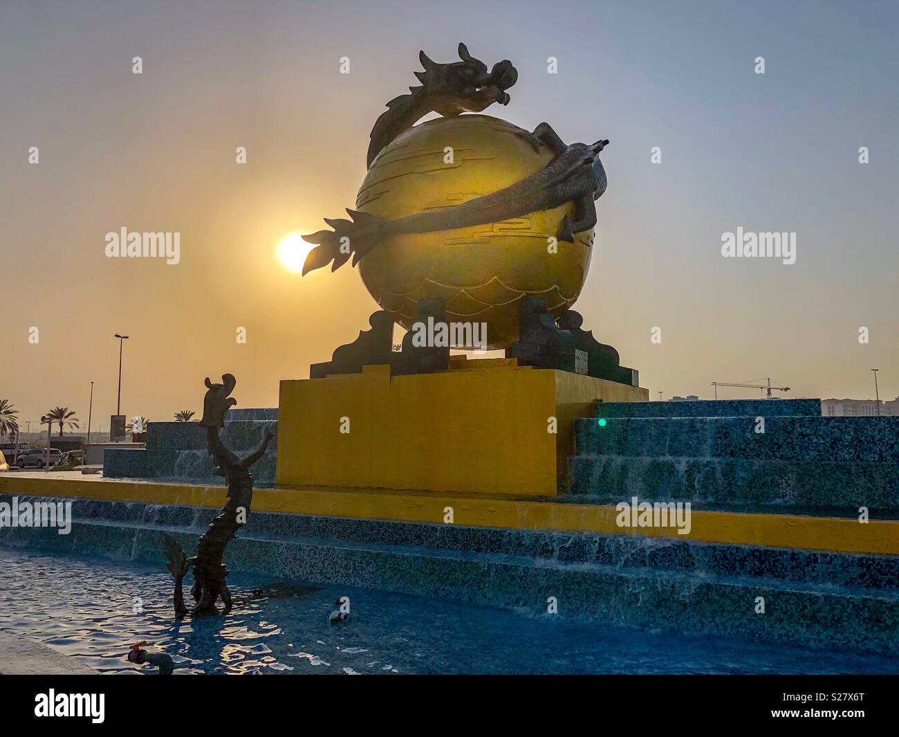Une sculpture de Dragon enroulé autour de Golden Globe en face de Dragon Mart Dubai Banque D'Images
