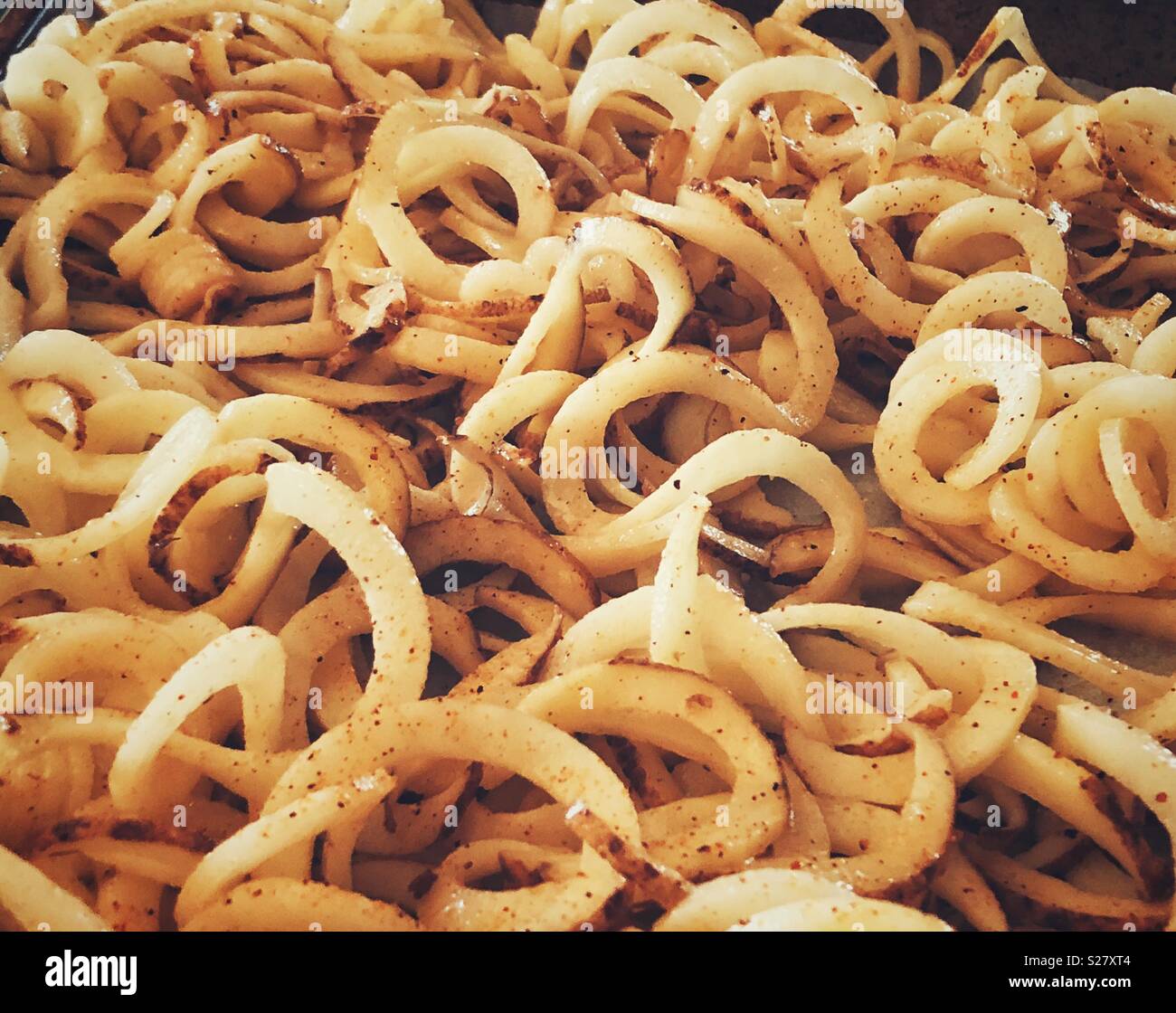 Pommes de terre blanches renforts spiralés sur une plaque de cuisson Banque D'Images