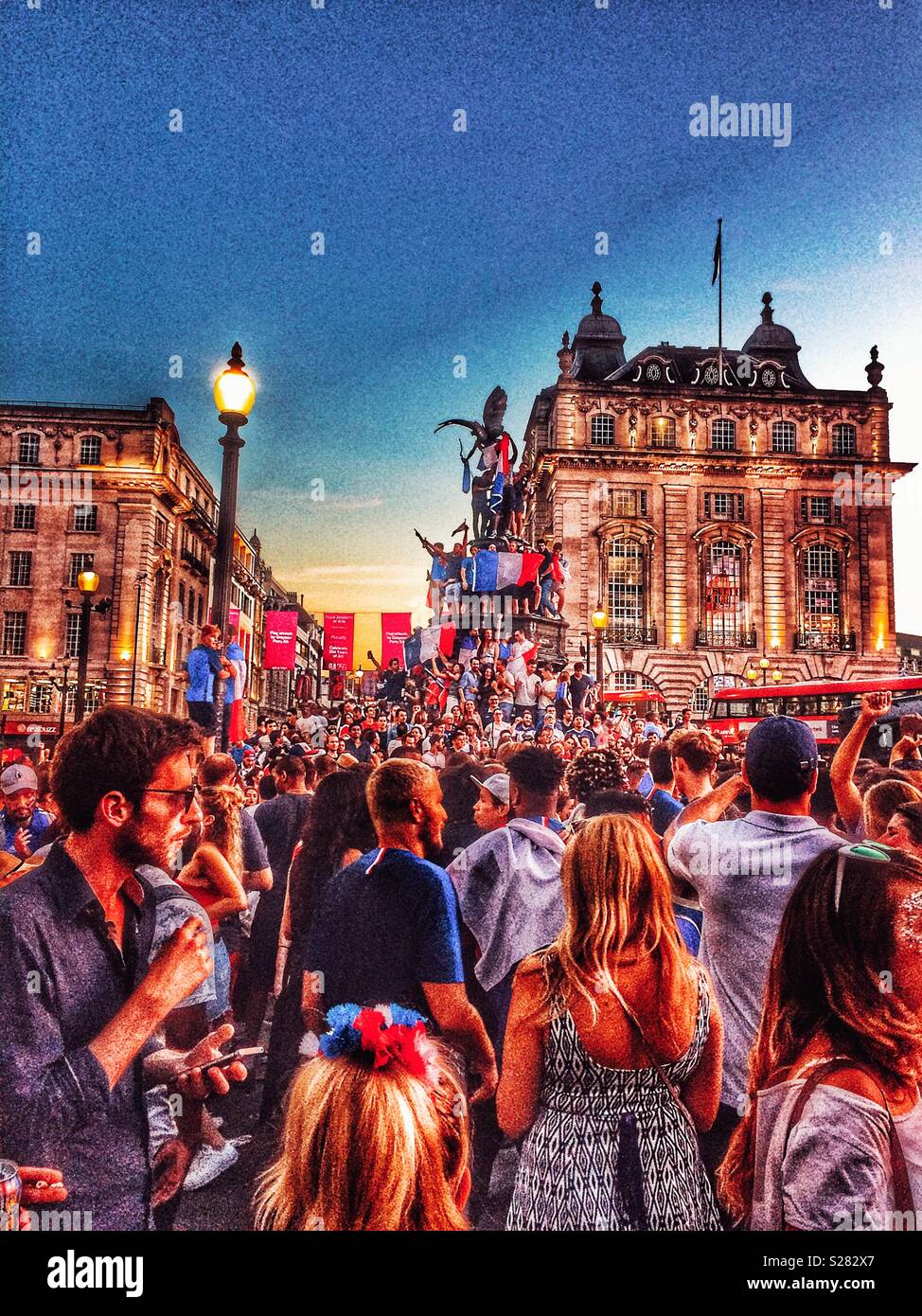 Les fans de football français de célébrer la Coupe du Monde France victoire par escalade statue d'Eros avec drapeau français (Tricolor), Piccadilly Circus, Londres - Image de stock capturée avec un smartphone
