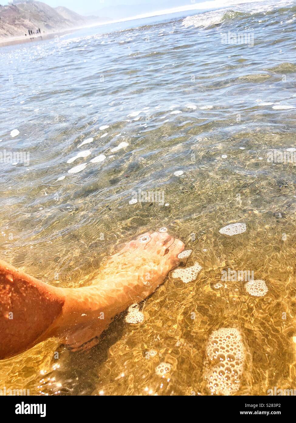 Se rafraîchir à la plage, les pieds nus immergées dans la mer d'eau salée  froide claire rive Photo Stock - Alamy