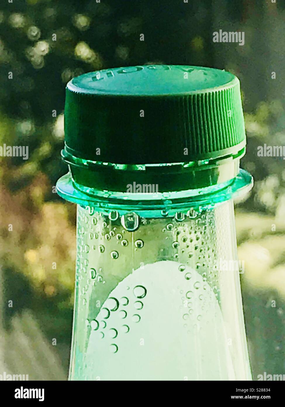 Haut de bouteille d'eau gazeuse avec l'eau gelée et cool bulles sous la partie supérieure verte. - Image de stock capturée avec un smartphone