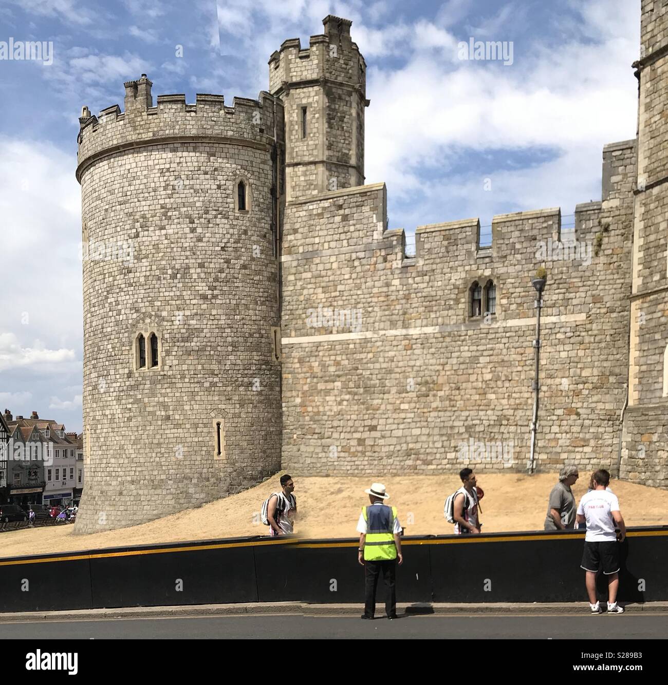 Les gens faisant la queue pour entrer dans le château de Windsor, en Angleterre, avec un gardien qui les aident. Banque D'Images